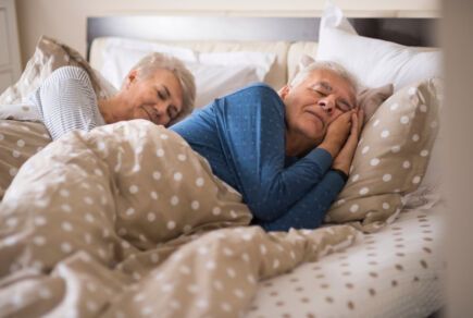 Couple qui profite d'un bon sommeil dans leur lit.
