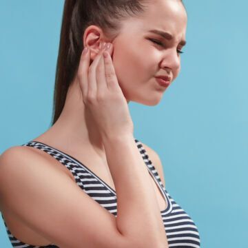 Femme qui a mal aux oreilles à cause d'une otite. Freepik