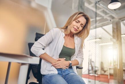 Femme qui se serre le ventre pendant une intoxication alimentaire.