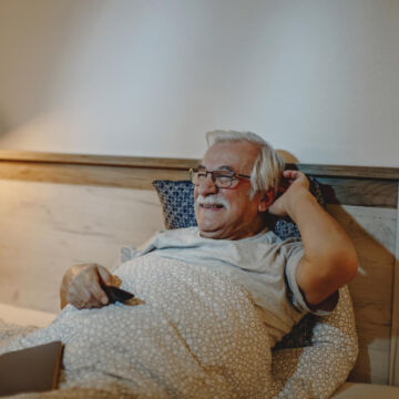 Homme âgé, à la retraite, relaxé dans son lit après avoir libéré des endorphines en faisant du sport.
