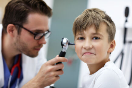 Enfant en consultation pour otite. Médecin l'observe avec un otoscope. Illustration de la prise en charge attentive des problèmes auditifs chez les jeunes patients. Freepik
