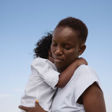 Femme qui tient son fils dans les bras quelques semaines après l'accouchement. Début d'un syndrome post-partum. Freepik