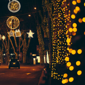 Fin d'année, rue éclairée avec les lumières de Noël. Pensons à celles et ceux qui en ont besoin.