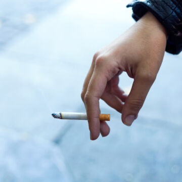 Femme qui tient une cigarette à la main. Le tabagisme est la cause principale de cancer du poumon.