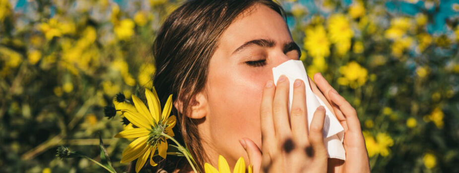 Jeune femme avec une sinusite dans un champ de fleurs.