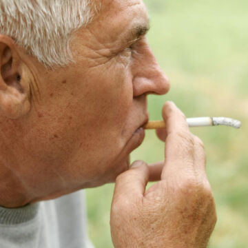 Homme âgé qui fume une cigarette.