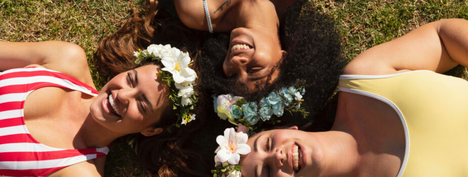 Trois jeunes femmes allongées dans l'herbe pour symboliser la journée pour la santé des femmes du 28 mai